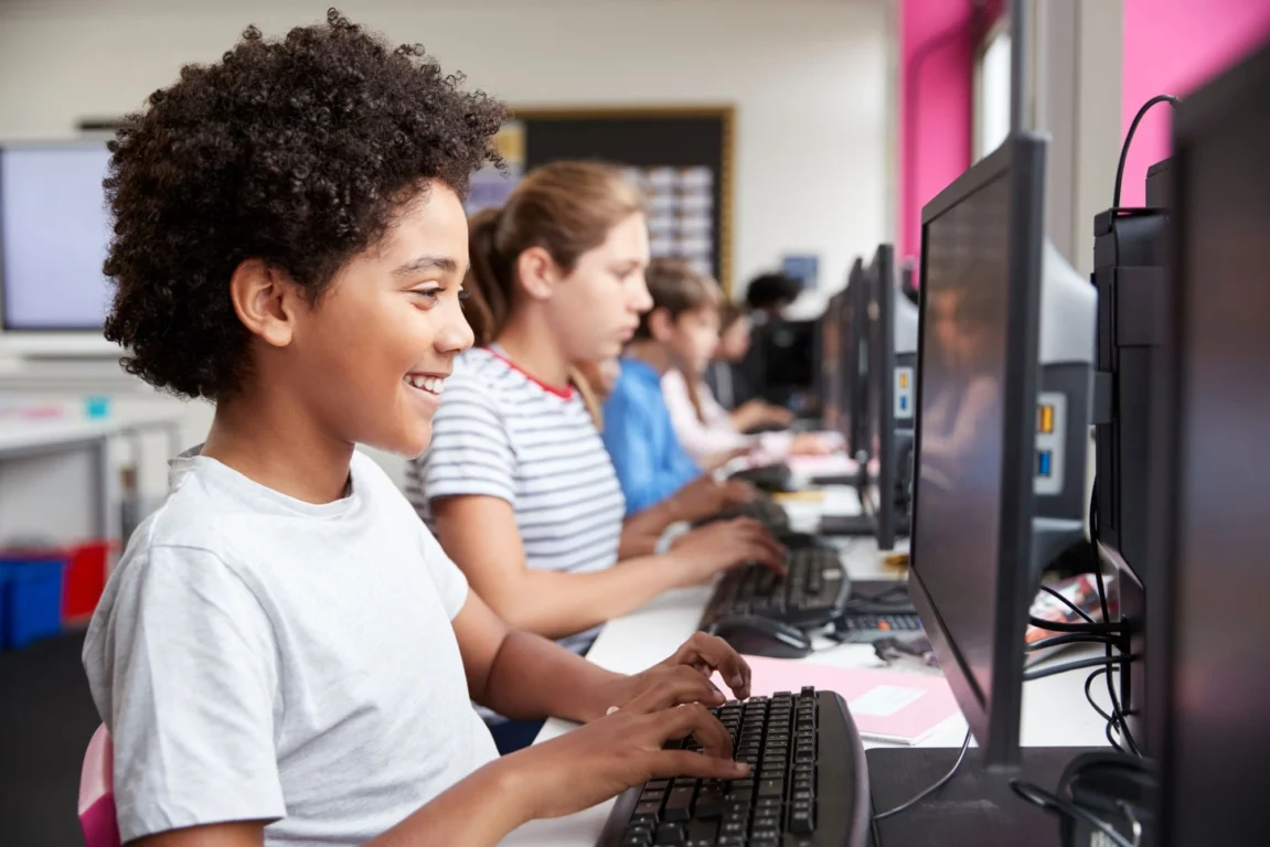 Children at laptop during IT lesson.