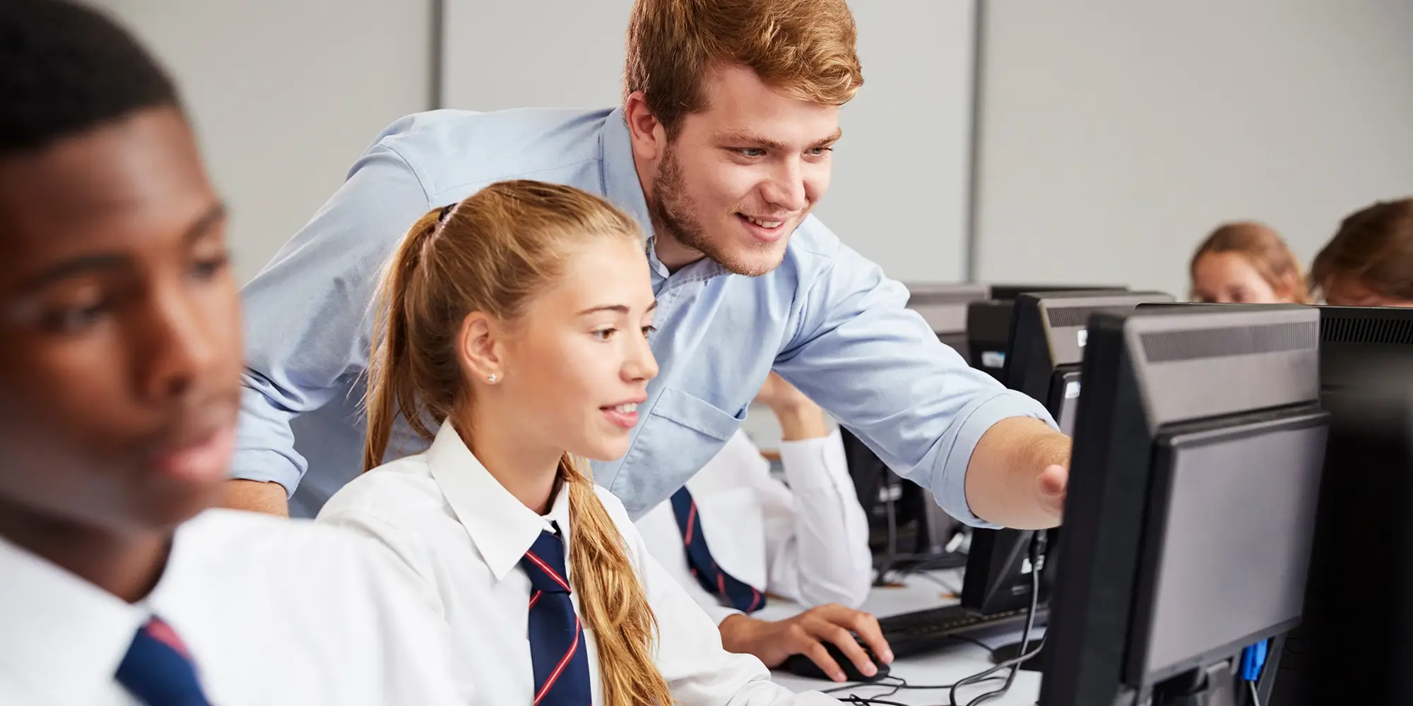 Teenage Students Wearing Uniform Studying In IT Class